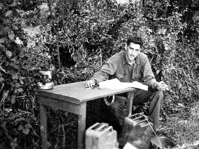J.D. Salinger writing at a table outside