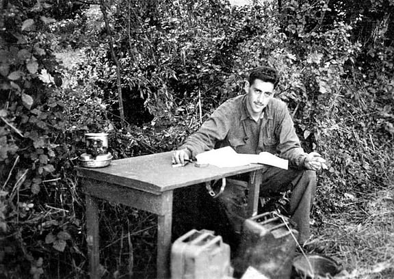 J.D. Salinger writing at a table outside